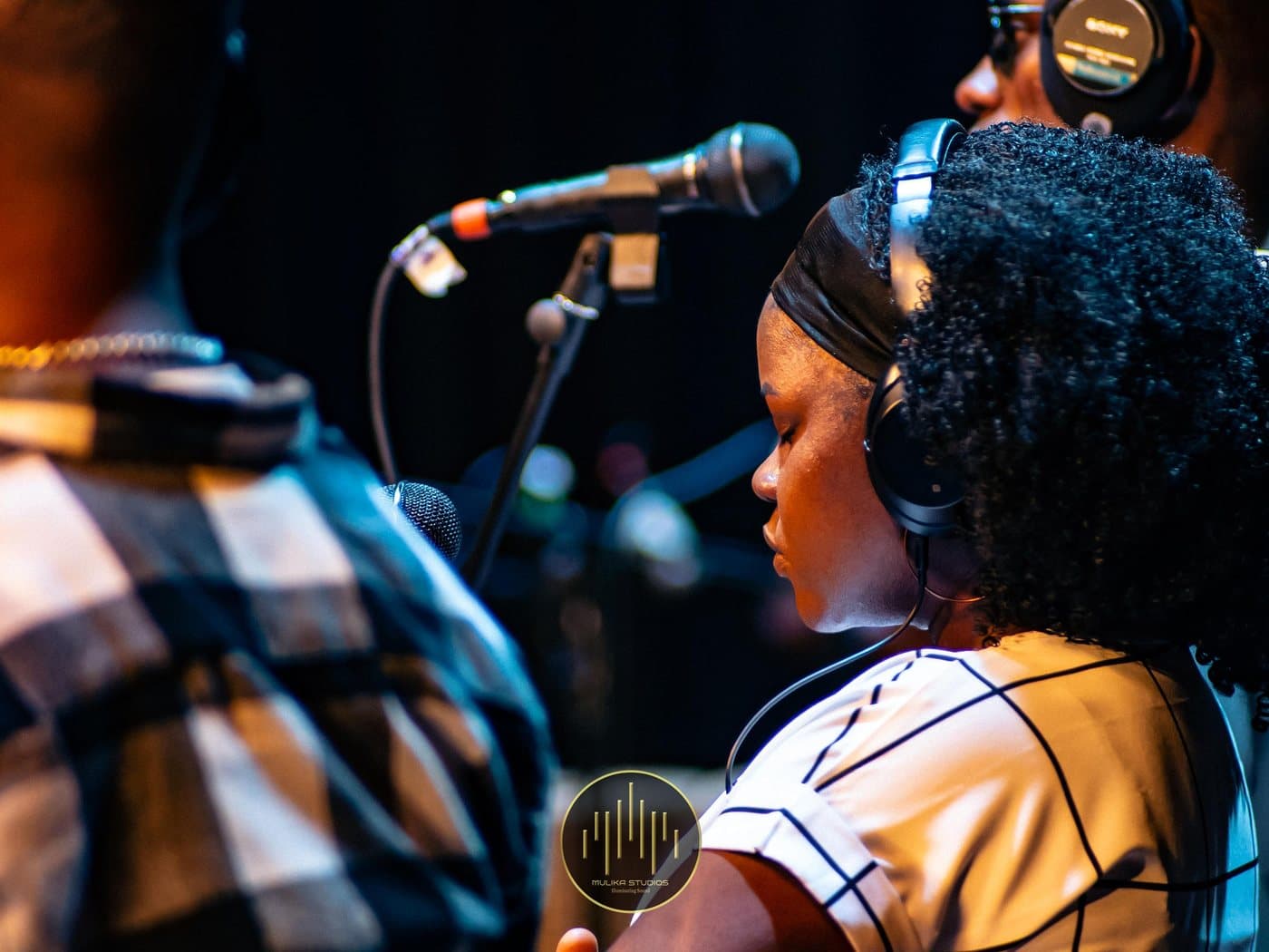 Backing vocalists at their mics
